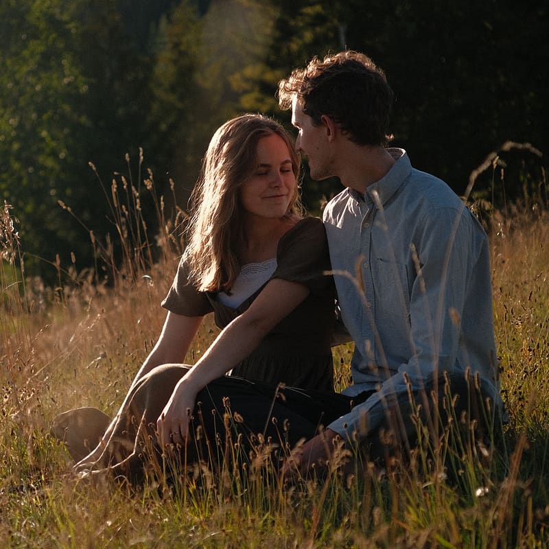 Lily & Elijah sitting in a field.