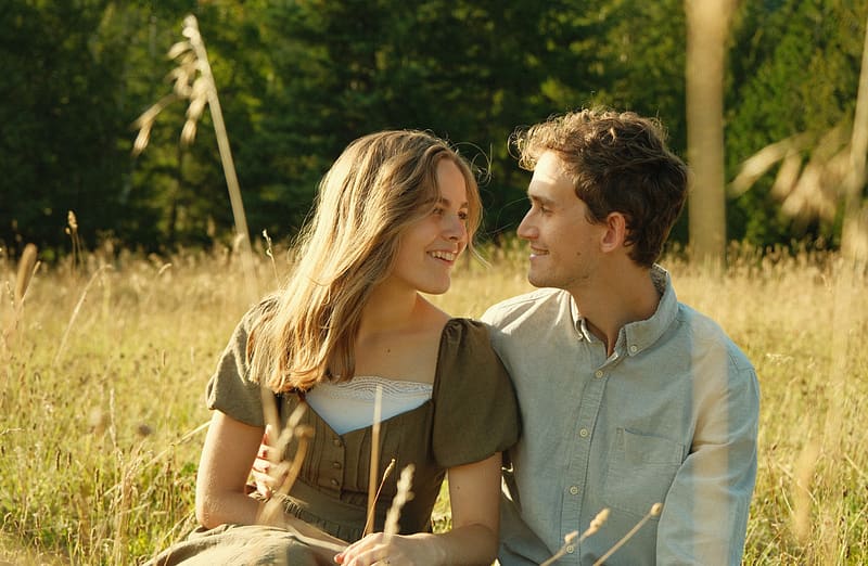 Lily and Elijah sitting in a field of grass.
