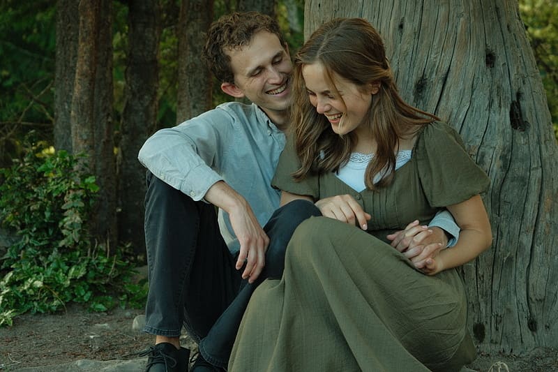 Lily and Elijah sitting by a tree stump