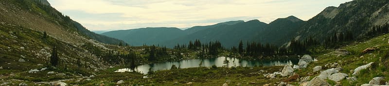 A scenic view of a lake surrounded by mountains and trees